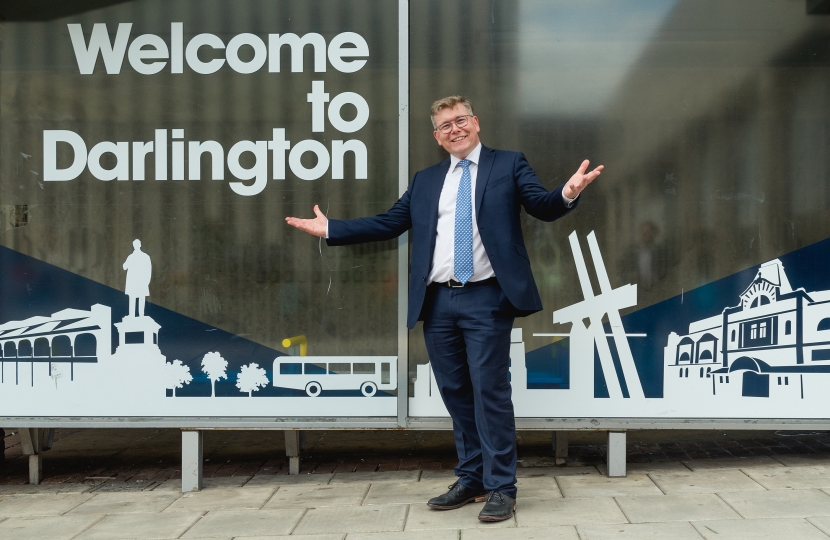 Peter Gibson in front of "Welcome to Darlington" sign